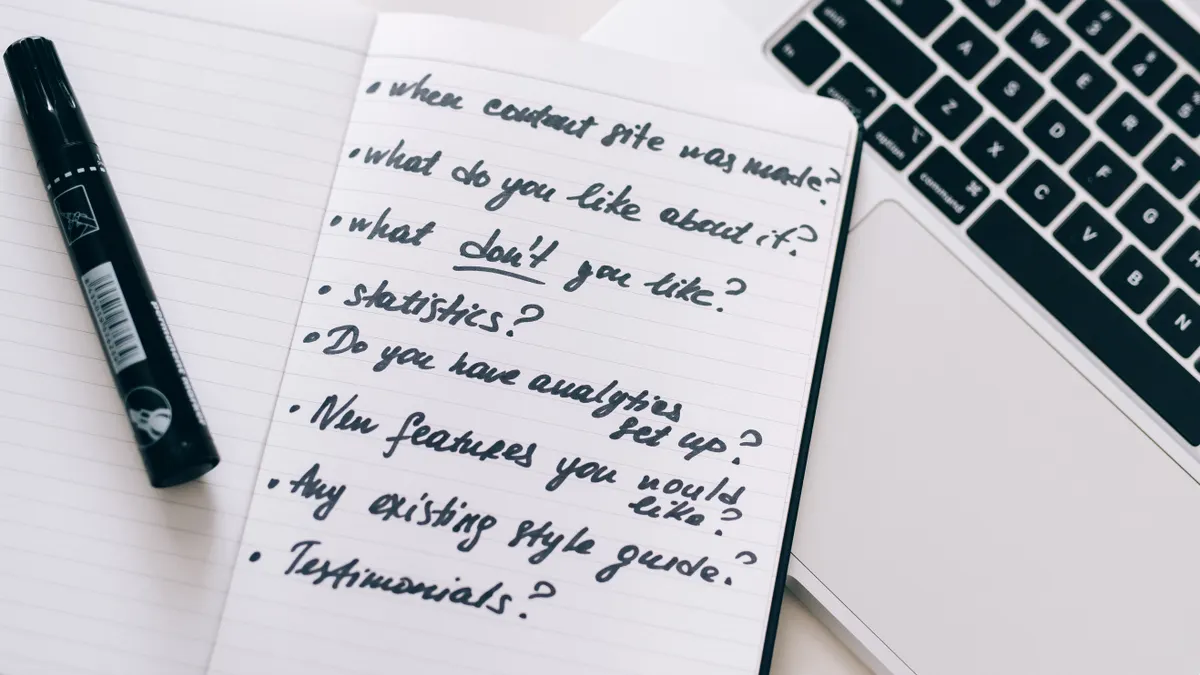 How to Use AI for Meeting Notes and Action Items open notebook with handwritten bullet points beside a laptop