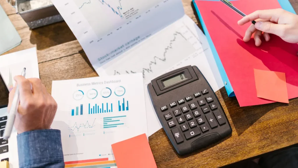 calculator with financial charts and paperwork on a desk