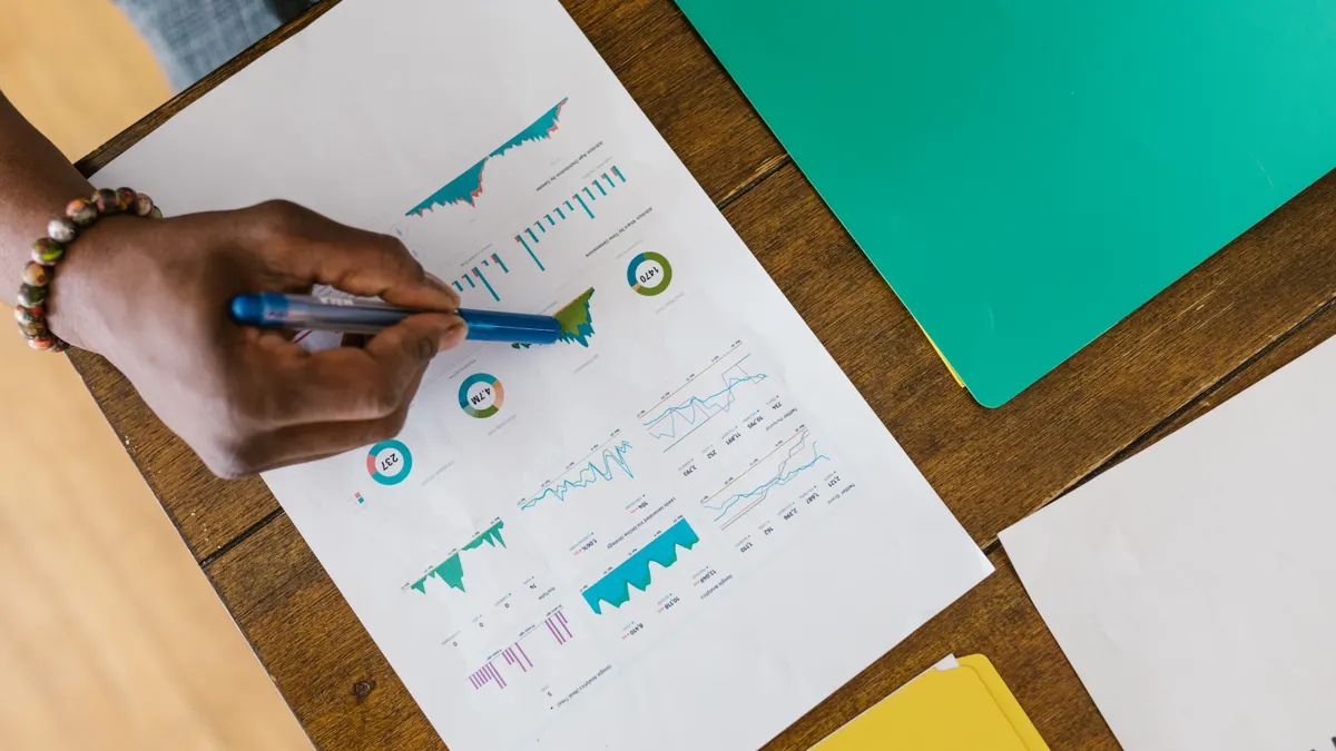 How U.S. Tech Startups Raise Seed Funding hand reviewing charts and graphs on paper at a desk